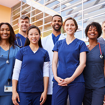 a group of medical professionals standing together and smiling at the camera